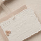 wedding rsvp card with blind letterpress leaf vine printed on handmade cotton paper and styled with a light blush return envelope 