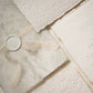 a close up of a sage green floral vellum wrap with letterpress wedding invitation suite on ivory handmade cotton paper
