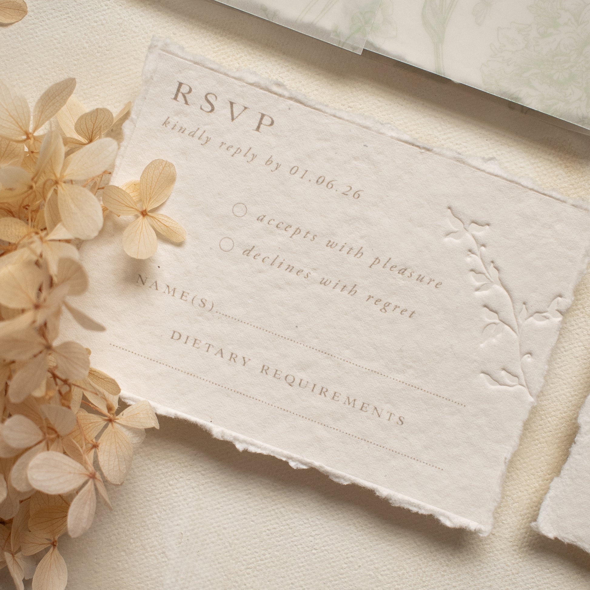 wedding rsvp card with blind letterpress leaf vine printed on handmade cotton paper and styled with beige dried flowers