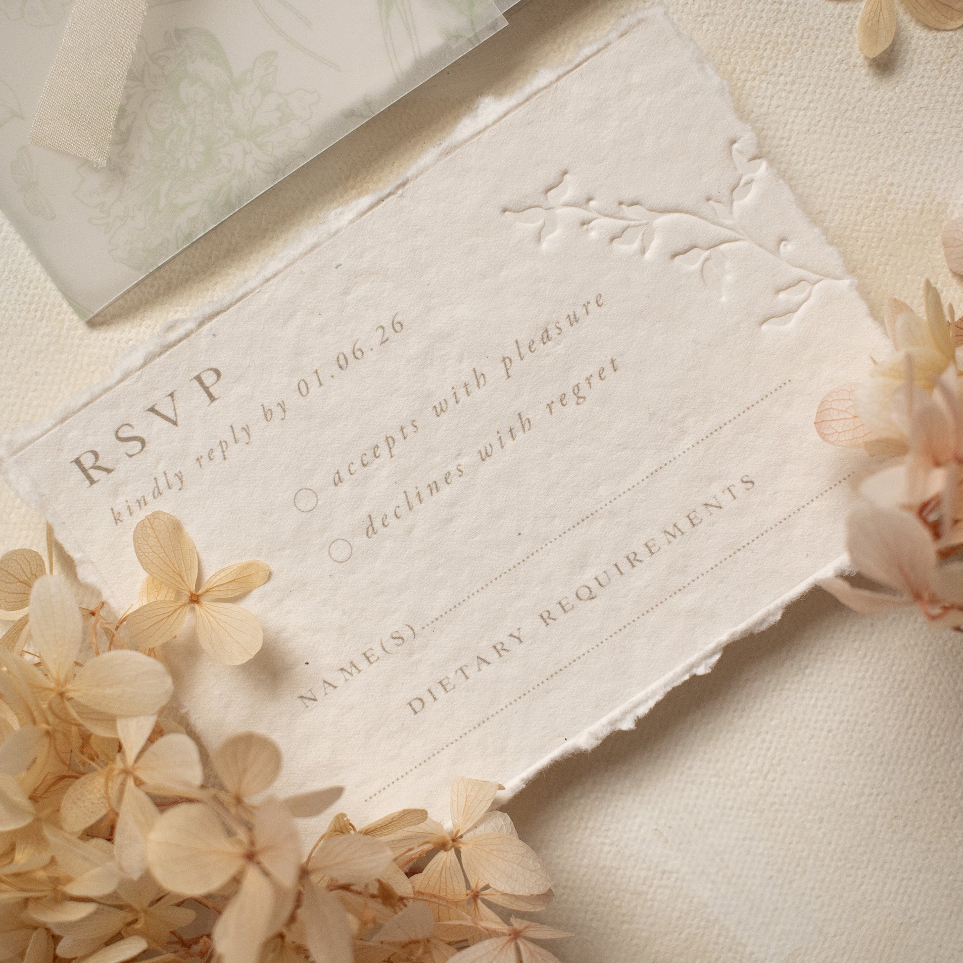 wedding rsvp card with blind letterpress leaf vine printed on handmade cotton paper and styled with beige dried flowers