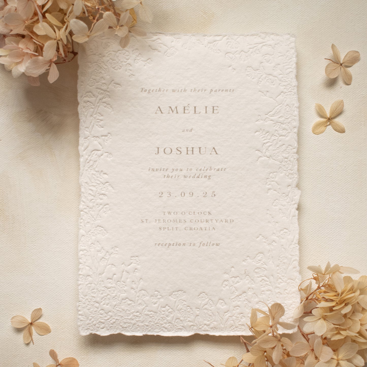 blind letterpress wedding invitation on handmade cotton paper with delicate floral detailing, styled with beige coloured dried hydrangeas